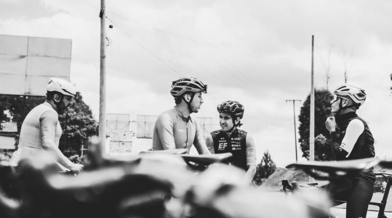 自転車のそばで話すサイクリストたちのモノクロ写真